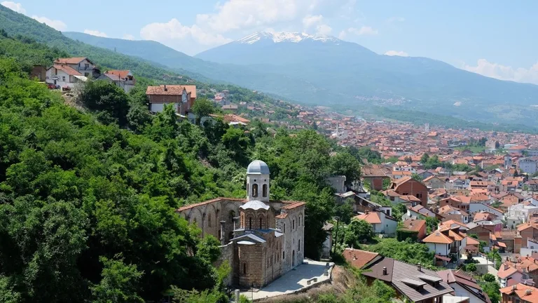 Panoramic view over Prizren with a historic church and mountains
